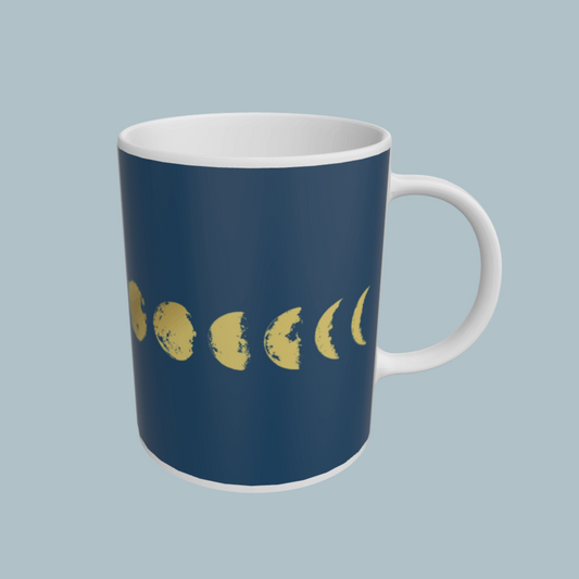 Navy blue mug with yellow moon phases on a light gray background