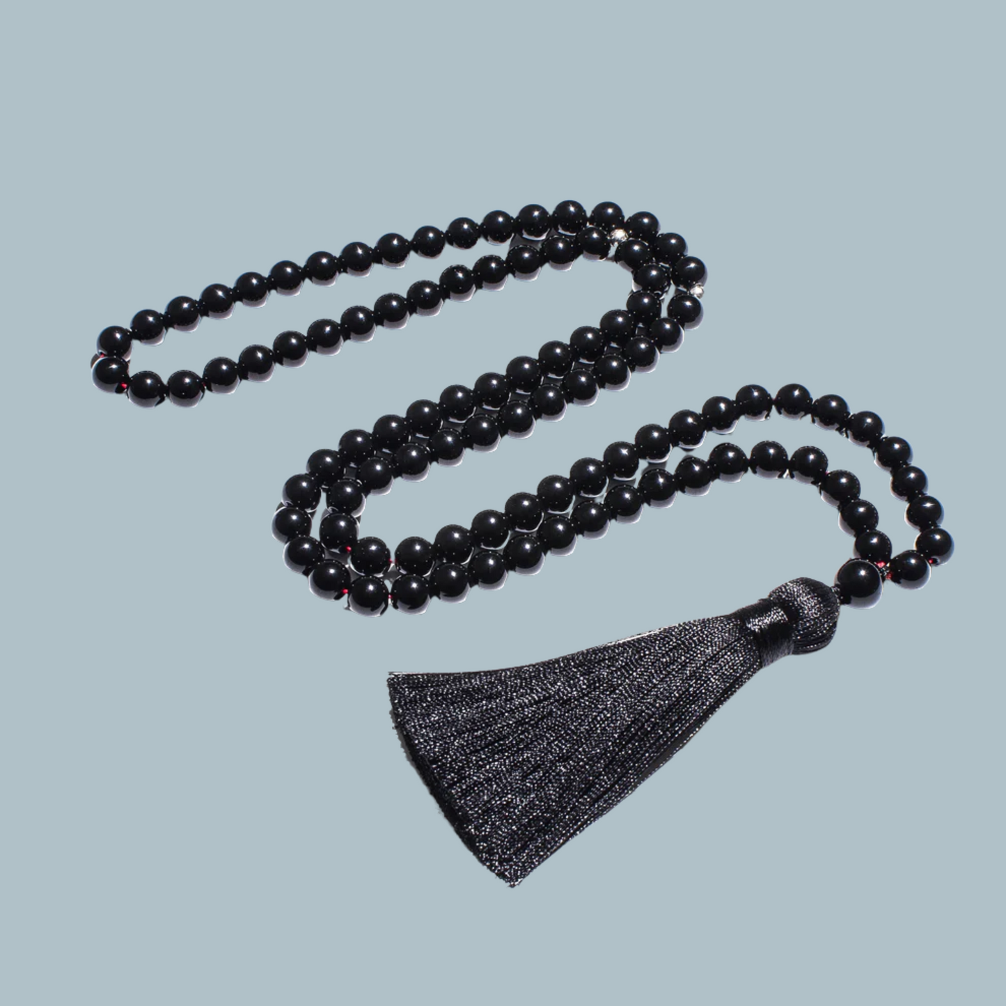 99-bead Black Onyx tasbih elegantly laid out, showcasing deep black tones