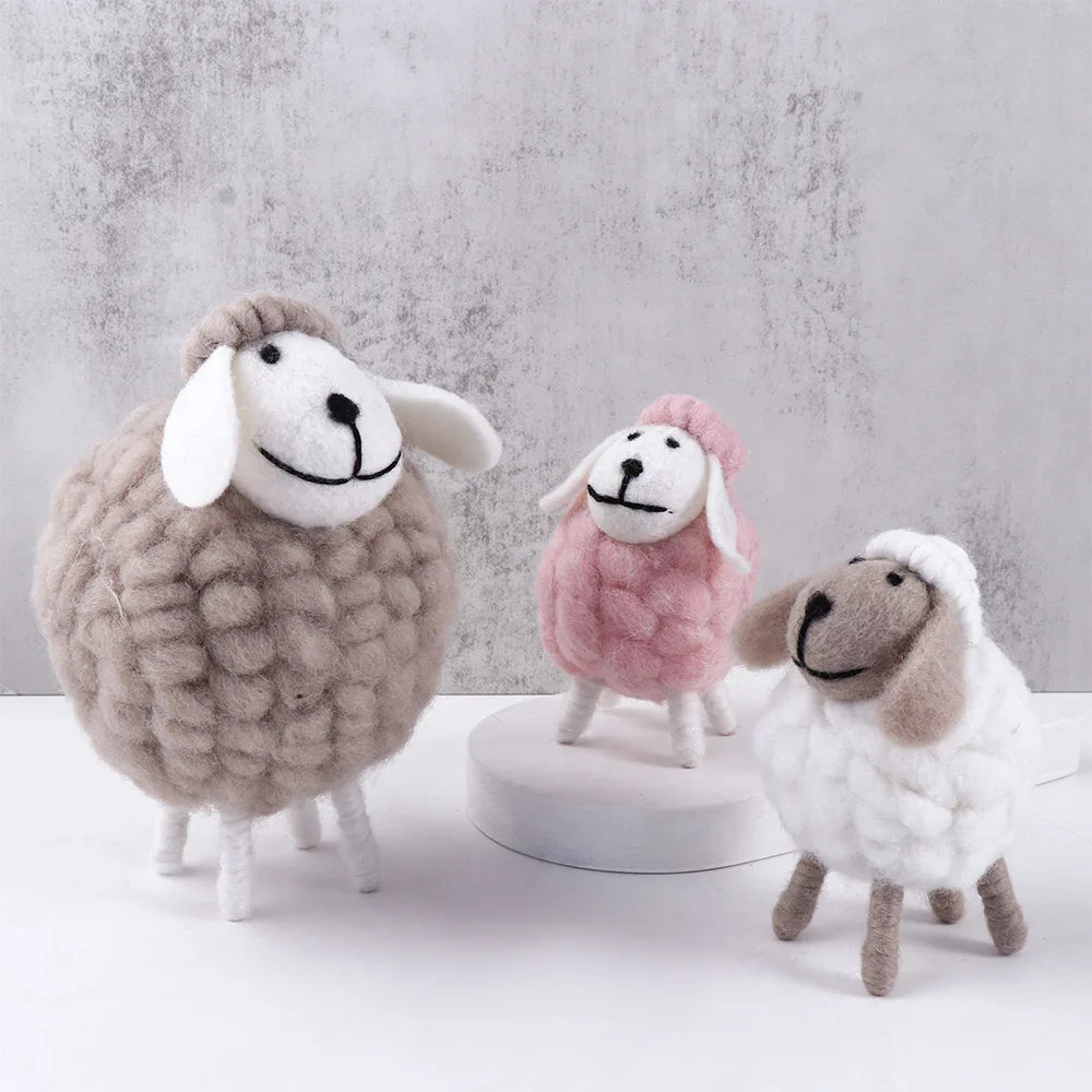 Felt sheep trio in grey, pink, and white on soft lifestyle background
