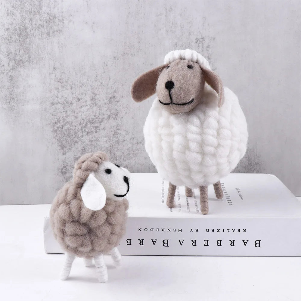 Small grey and large white felt sheep on light background