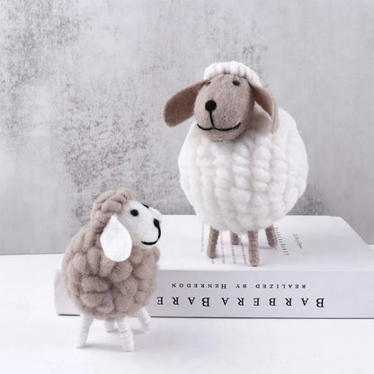 Small grey and large white felt sheep on light background