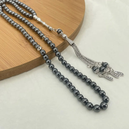 Close-up of Hematite tasbih on wooden board showing bead detail