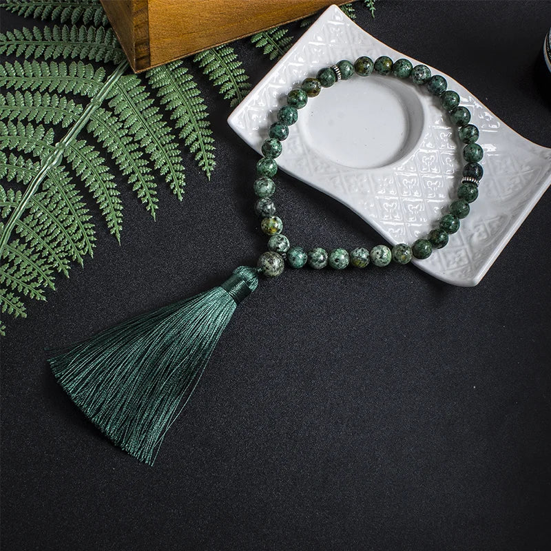 33-bead Green Jasper tasbih laid out fully in lifestyle setting