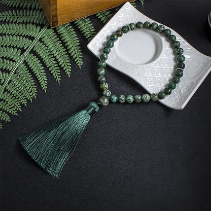 33-bead Green Jasper tasbih laid out fully in lifestyle setting