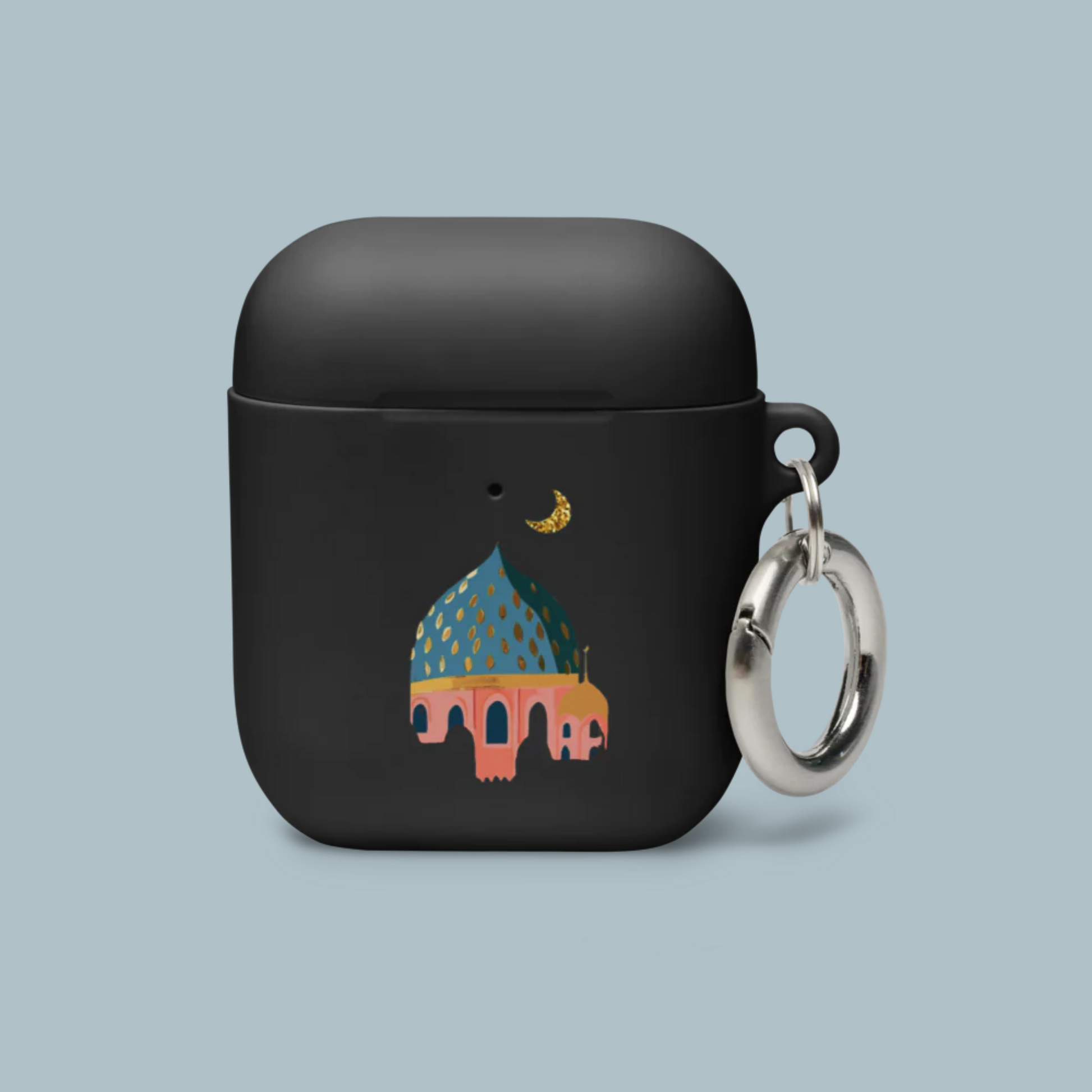 Black airpod case with a colorful illustration of a Masjid and keychain on a light blue background