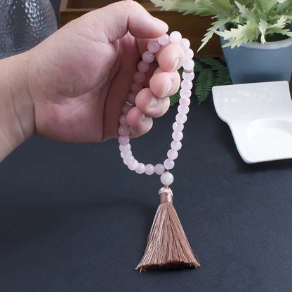 33-bead Rose Quartz tasbih gently held in hand, displaying bead clarity