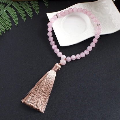Soft lighting lifestyle image of 33-bead Rose Quartz tasbih with tassel detail