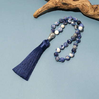 33-bead Sodalite tasbih placed beside driftwood for natural presentation
