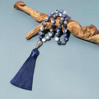 33-bead Sodalite tasbih arranged across a piece of driftwood
