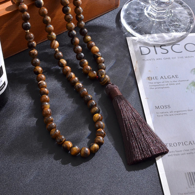 99-bead Tiger Eye tasbih in styled setting, draped in natural light