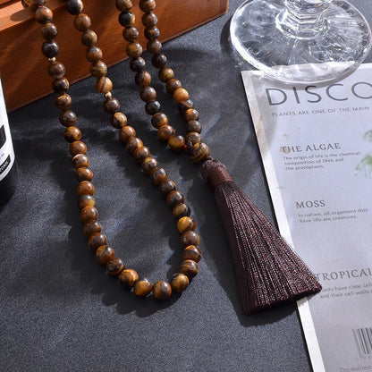 99-bead Tiger Eye tasbih in styled setting, draped in natural light